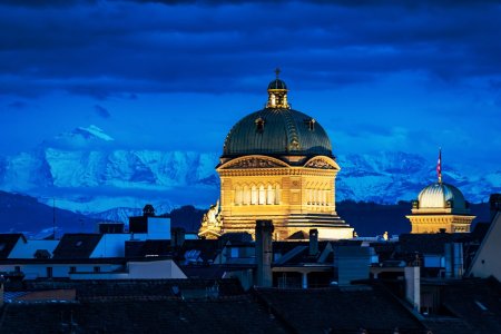 Majestetisch thrront das Bundehaus über der historischen Altstadt von bern. Im Hintergrund leuchtet das Jungfraus-Massiv.