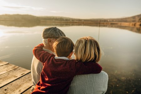 Photo of grandparents and grandson on a lake dock