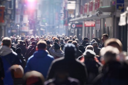 A crowd of people on a bright winter day on an urban high street in Europe, anonymous faces