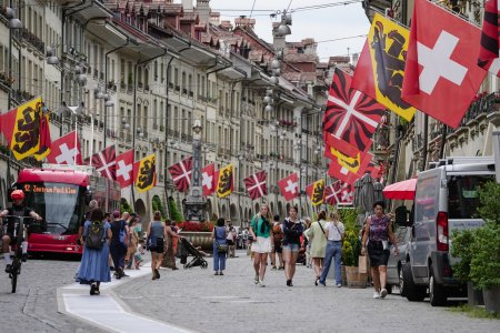 Bern, Switzerland - July 22, 2024: Old town view with tourists and Swiss and Canton flags in Kramgasse street in Bern Switzerland