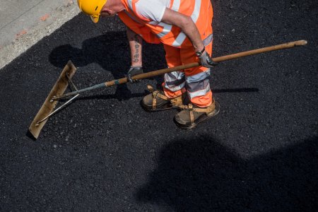 Ein Bauarbeiter arbeitet an den Belagsarbeiten der Autobahn A2, in Mendrisio, im Tessin, am Donnerstag, 12. Mai 2015. (KEYSTONE/TI-PRESS/Gabriele Putzu)