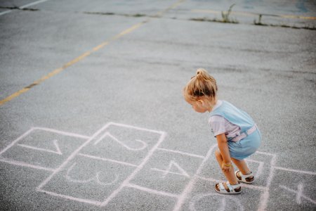 Girl playing hopscotch in public park