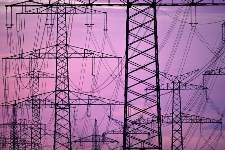 ARCHIV - 29.06.2022, Nordrhein-Westfalen, Niederaum: Strommasten stehen in der Dmerung am Morgen auf einem Feld. Die Energieversorger bleiben laut Gerichtsbeschluss an ihre Preisgarantien gebunden. (zu dpa "Gericht: Energieversorger an Preisgarantie gebunden") Foto: Federico Gambarini/dpa +++ dpa-Bildfunk +++ (KEYSTONE/DPA/Federico Gambarini)