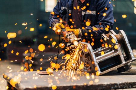 Metal worker using a grinder