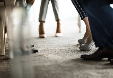 Large group of unrecognizable business people's legs during a meeting.