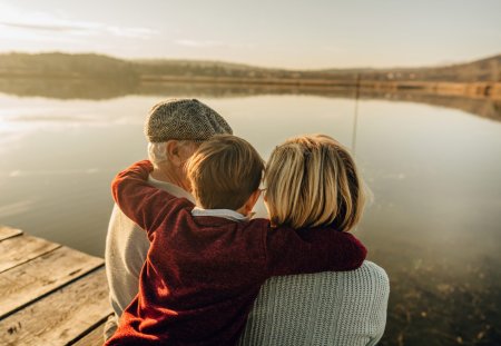 Photo of grandparents and grandson on a lake dock