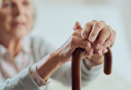 Cropped shot of a senior woman holding onto her walking stick while in the living room of a nursing home