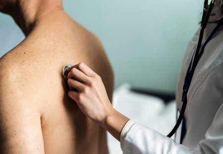 Doctor checking her mature patient's heart during a consultation in a medical center