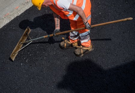 Ein Bauarbeiter arbeitet an den Belagsarbeiten der Autobahn A2, in Mendrisio, im Tessin, am Donnerstag, 12. Mai 2015. (KEYSTONE/TI-PRESS/Gabriele Putzu)