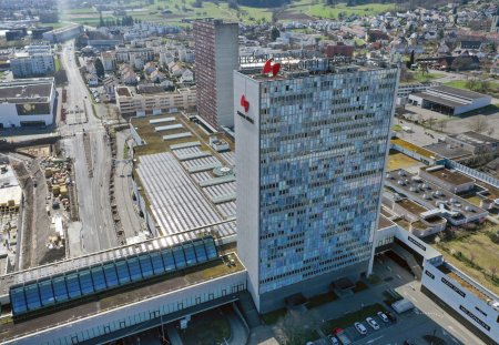 Spreitenbach  in the district of Baden (canton of Aargau) in Switzerland, located in the Limmat Valley. The image shows several residential buildings and the Shoppi Tivoli in the foreground. The high angle image was captured during springtime.