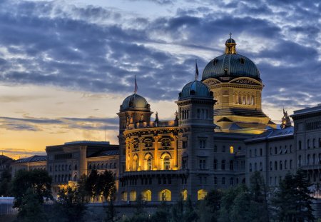 In the center of the city of Bern and on top of the river Aar, the imposing the parliament of Bern. It dates from 1902 and has a large green dome.