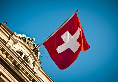 swiss flag waving on historic building