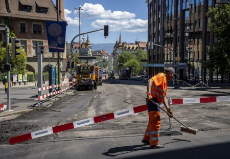 Un ouvrier balaie la route afin de pouvoir poser un nouveau revetement, un enrobe bitumineux de goudron phonoabsorbant, lors d?une conference de presse du syndicat UNIA afin de denoncer que sur les chantiers publics de genie civil, les conditions legales de protection des travailleurs ne sont pas reunies et mettent en danger leur sante, en periode de canicule. Une bonne soixantaine de chantiers a ete visitee par Unia et une trentaine de denonciations ont ete faites aupres des inspections du travail. Elles concernaient notamment l?absence de pauses regulieres, de mise a disposition d?eau et d?un lieu de pause au frais, ou encore la pratique de travaux lourds aux heures tres chaudes. (KEYSTONE/Martial Trezzini)