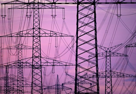 ARCHIV - 29.06.2022, Nordrhein-Westfalen, Niederaum: Strommasten stehen in der Dmerung am Morgen auf einem Feld. Die Energieversorger bleiben laut Gerichtsbeschluss an ihre Preisgarantien gebunden. (zu dpa "Gericht: Energieversorger an Preisgarantie gebunden") Foto: Federico Gambarini/dpa +++ dpa-Bildfunk +++ (KEYSTONE/DPA/Federico Gambarini)