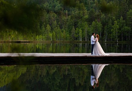 Happy newlyweds in the summer on the lake