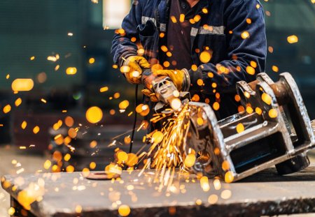 Metal worker using a grinder